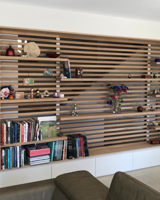 Bibliothèque en chêne sur mesure : claustra à lames horizontales, étagères ouvertes et rangements fermés en partie basse
